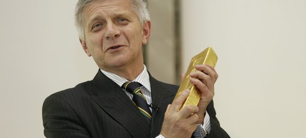 Marek Belka - prezes NBP w latach 2010-2016, trzymający jedną ze sztabek złota.